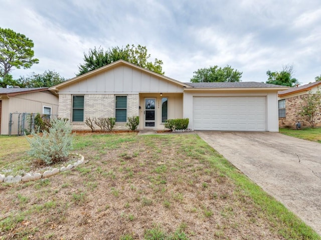 ranch-style home with brick siding, an attached garage, board and batten siding, a front yard, and driveway