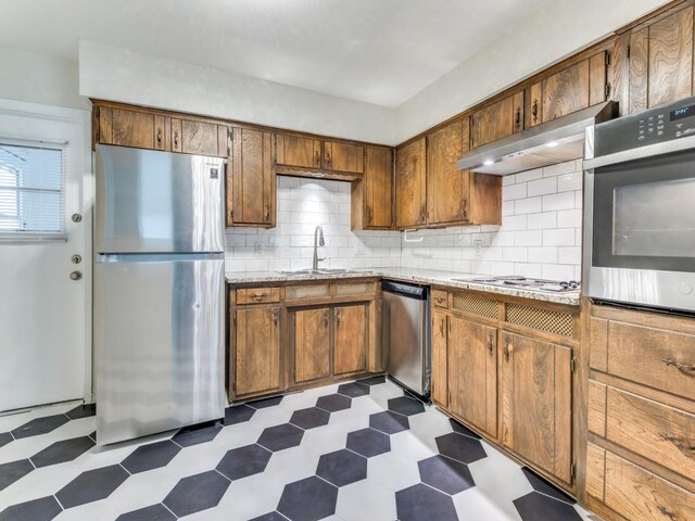 kitchen featuring backsplash, stainless steel appliances, and sink