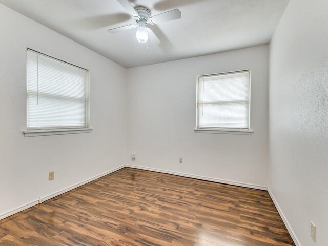 empty room with dark hardwood / wood-style flooring and ceiling fan