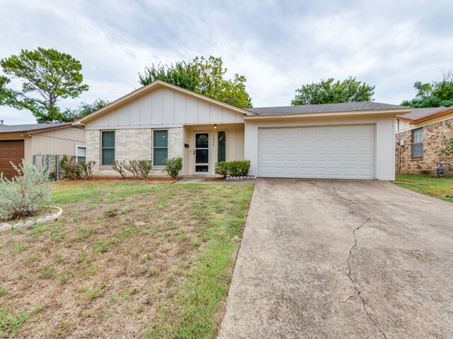 ranch-style home featuring a garage and a front lawn