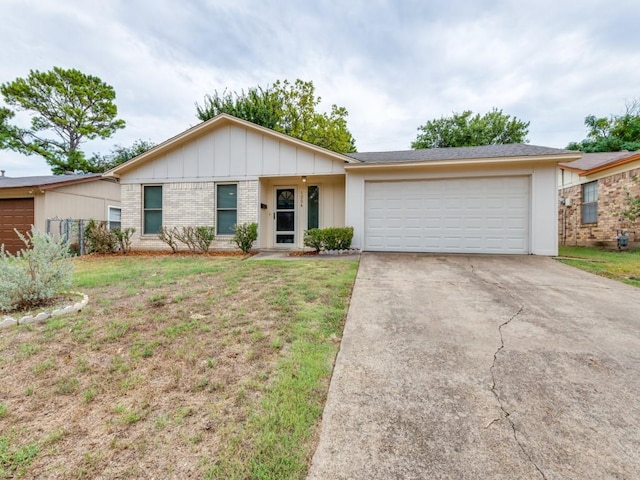 ranch-style home featuring brick siding, an attached garage, board and batten siding, driveway, and a front lawn