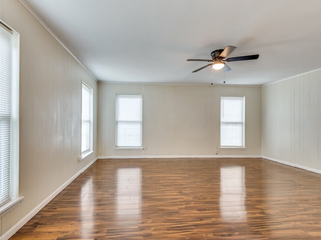 spare room with dark wood-type flooring, ceiling fan, and ornamental molding