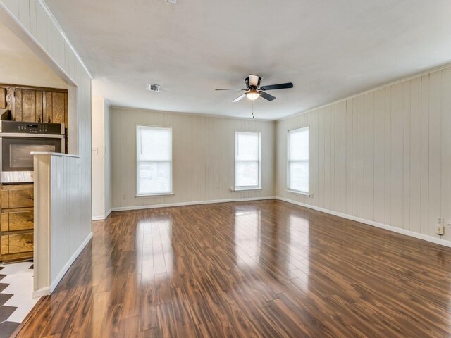 unfurnished living room featuring ceiling fan and dark hardwood / wood-style flooring