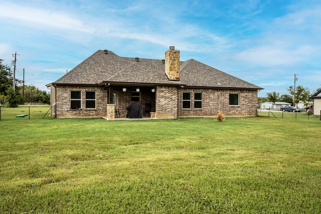 rear view of house featuring a yard and a patio area