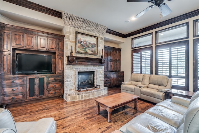 living room with hardwood / wood-style floors, ceiling fan, a fireplace, and crown molding