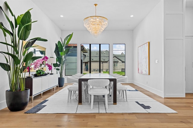 dining area featuring an inviting chandelier and light hardwood / wood-style flooring