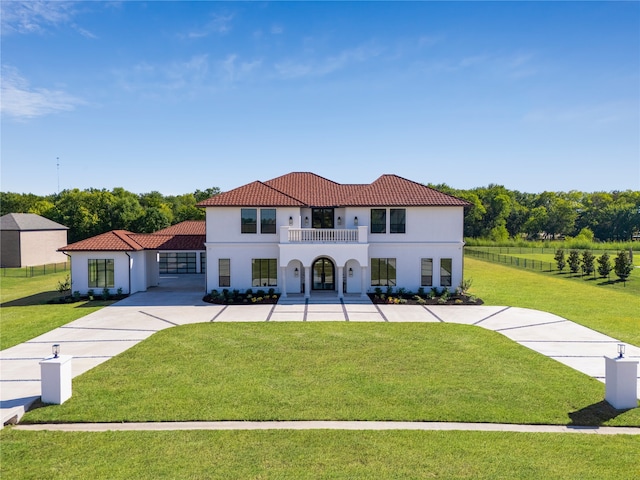 view of front of property featuring a balcony and a front yard