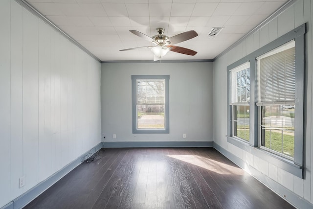 empty room featuring dark wood-type flooring, ceiling fan, and ornamental molding