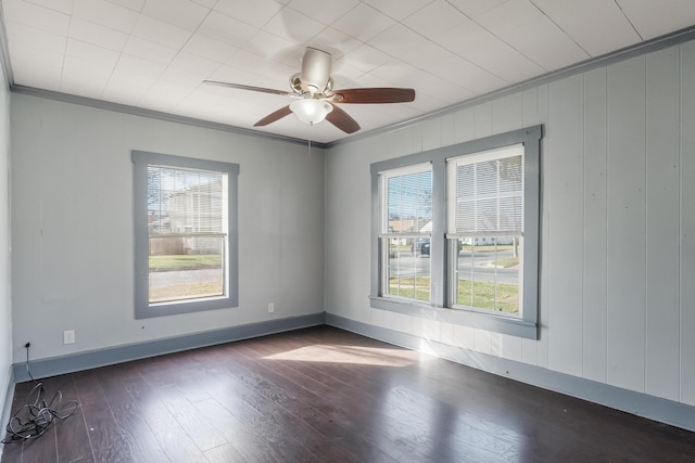 spare room featuring dark wood-type flooring, ornamental molding, and ceiling fan