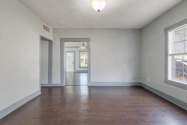 spare room with dark hardwood / wood-style floors and a textured ceiling