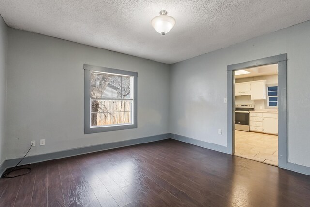 spare room with dark wood-type flooring and a textured ceiling