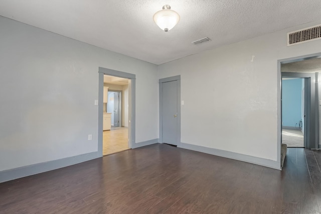 unfurnished room featuring dark hardwood / wood-style floors and a textured ceiling