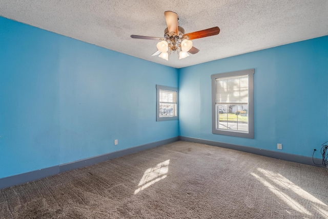 unfurnished room with ceiling fan, carpet, and a textured ceiling