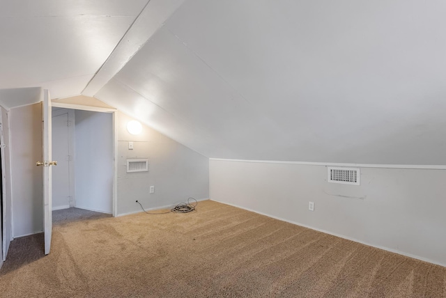 bonus room with vaulted ceiling and carpet flooring