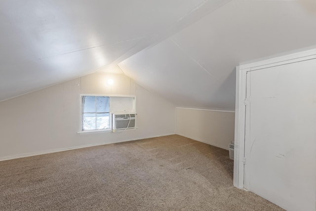 additional living space with cooling unit, lofted ceiling, and carpet flooring