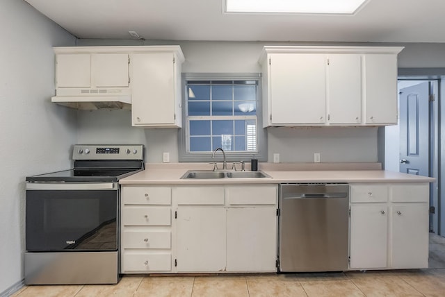 kitchen with light tile patterned flooring, appliances with stainless steel finishes, sink, and white cabinets