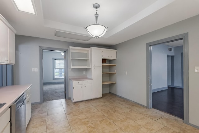 kitchen with white cabinetry, hanging light fixtures, and a raised ceiling