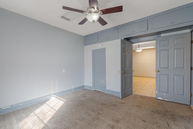 unfurnished bedroom featuring light carpet and ceiling fan