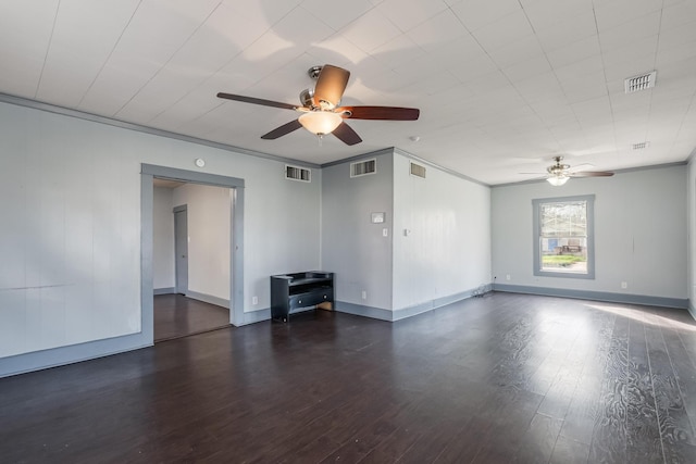 empty room featuring dark hardwood / wood-style flooring, ornamental molding, and ceiling fan