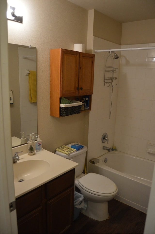 full bathroom with hardwood / wood-style flooring, toilet, vanity, and tiled shower / bath