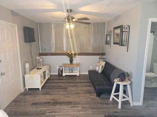 living area featuring a textured ceiling, ceiling fan, and dark hardwood / wood-style floors