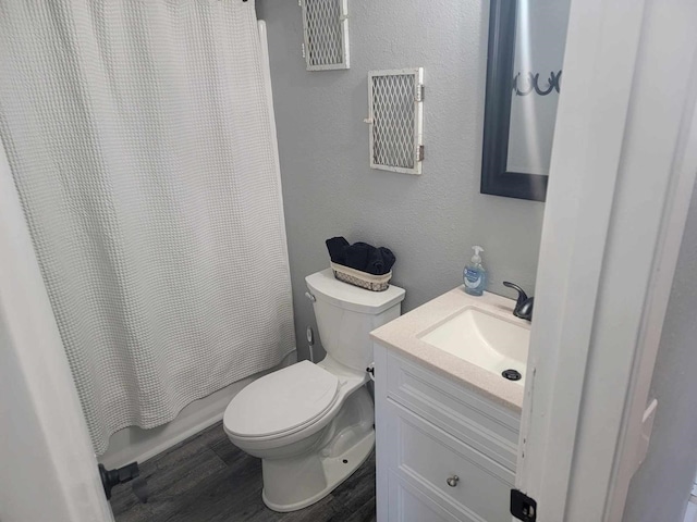 full bathroom featuring toilet, hardwood / wood-style flooring, shower / tub combo, and vanity