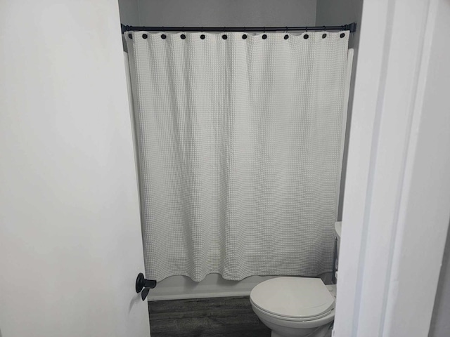 bathroom with shower / bath combo with shower curtain and toilet