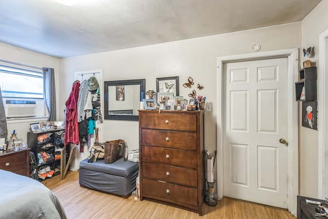 bedroom with cooling unit, a closet, light hardwood / wood-style floors, and a textured ceiling