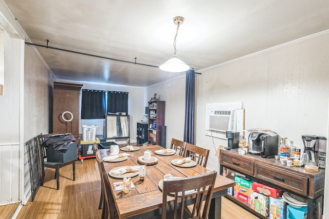 dining room with hardwood / wood-style flooring, a wall mounted air conditioner, and ornamental molding