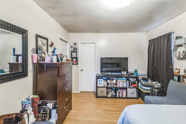 bedroom featuring a textured ceiling and light hardwood / wood-style flooring