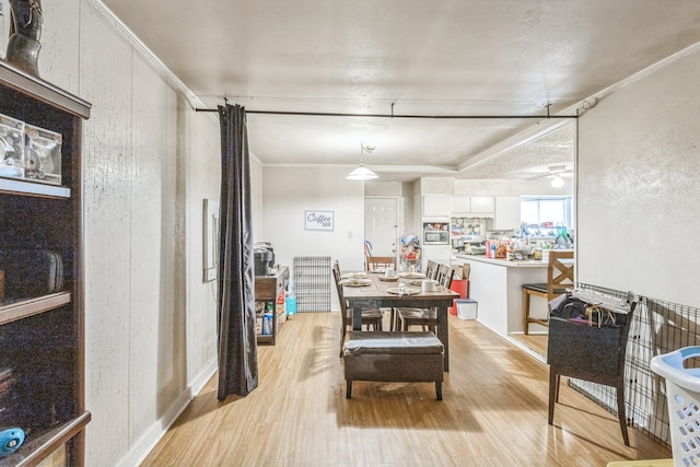 dining space featuring crown molding and light hardwood / wood-style floors