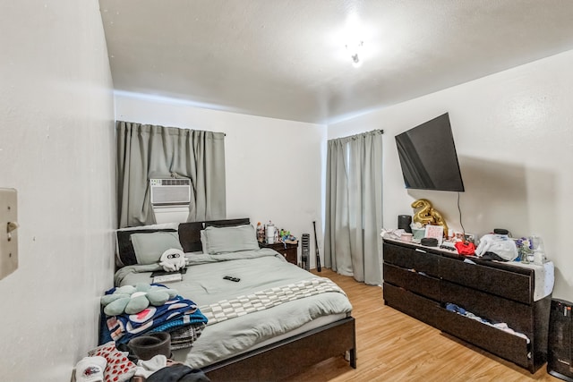 bedroom featuring cooling unit and light hardwood / wood-style flooring