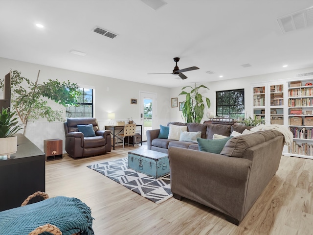 living room with light wood-type flooring and ceiling fan