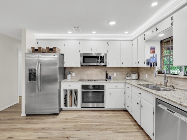 kitchen with appliances with stainless steel finishes, light wood-type flooring, white cabinetry, and sink