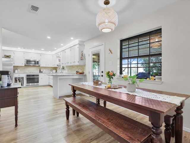 dining room featuring light wood-type flooring and sink