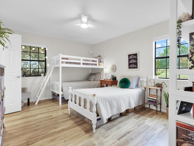 bedroom with multiple windows, light hardwood / wood-style floors, and ceiling fan