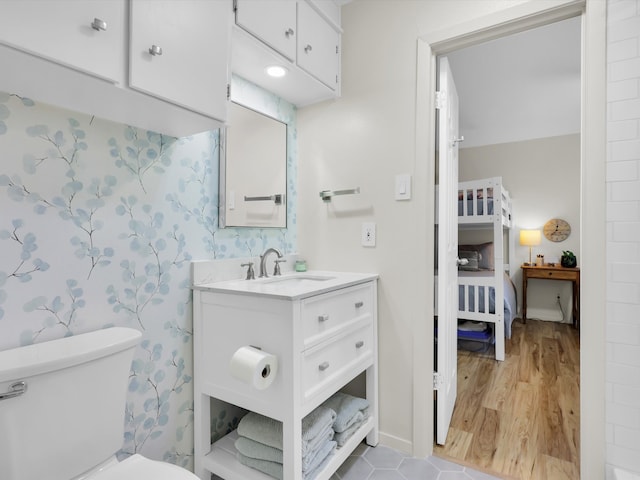 bathroom with hardwood / wood-style floors, vanity, and toilet