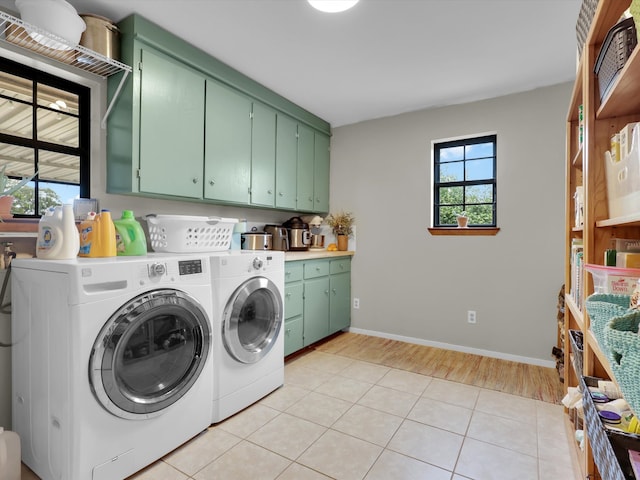 laundry room featuring cabinets, light tile patterned floors, and washing machine and dryer