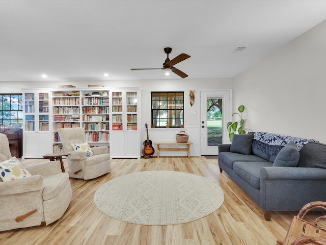 living room featuring ceiling fan, light hardwood / wood-style floors, and a healthy amount of sunlight