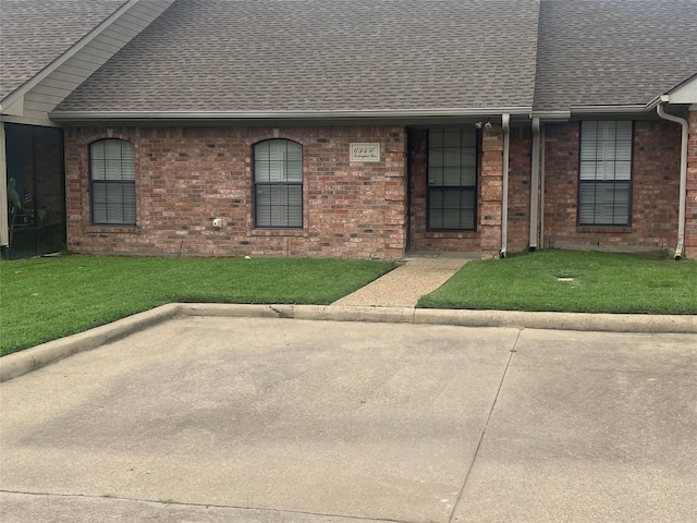 ranch-style house with a front lawn and a patio