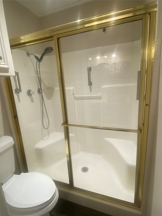 bathroom with an enclosed shower and toilet