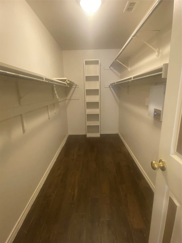 spacious closet featuring dark hardwood / wood-style flooring