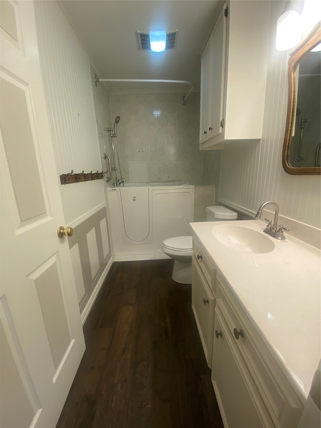 bathroom with wood-type flooring, toilet, and vanity