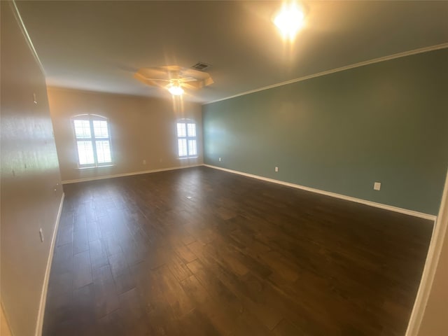 empty room featuring dark wood-type flooring, ceiling fan, and ornamental molding