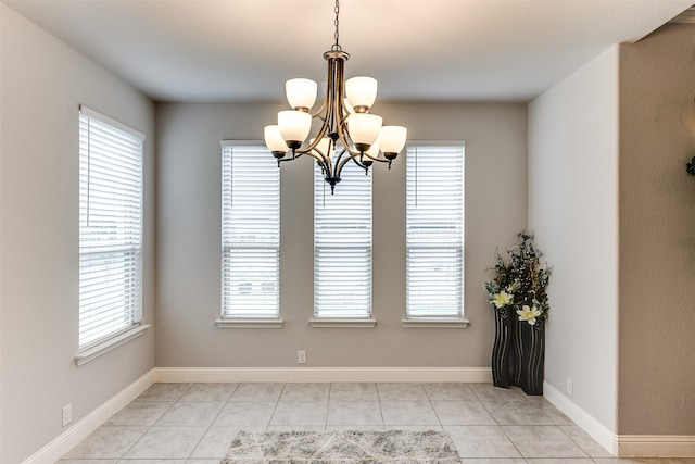 unfurnished dining area featuring light tile patterned floors and a chandelier