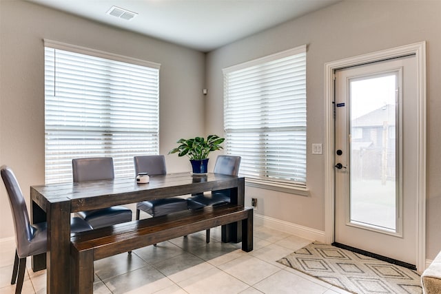 tiled dining room with a healthy amount of sunlight