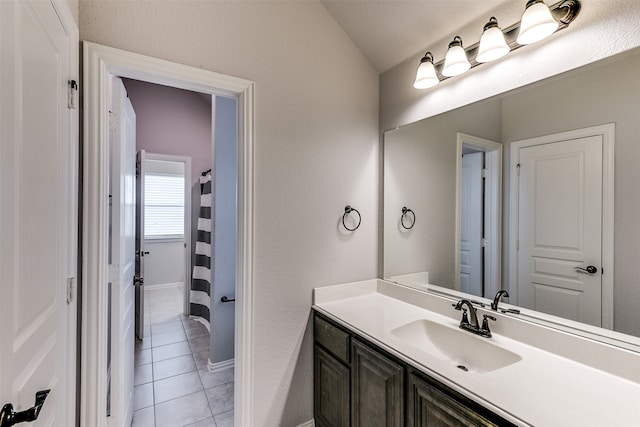 bathroom with tile patterned floors, lofted ceiling, a textured ceiling, and vanity