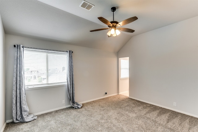 spare room with lofted ceiling, ceiling fan, and light colored carpet