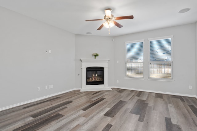 unfurnished living room with ceiling fan and hardwood / wood-style floors