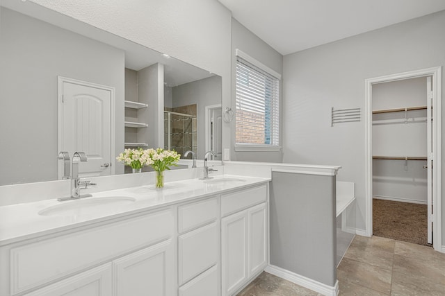 bathroom with a shower with door, tile patterned floors, and vanity